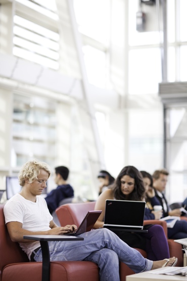 students with laptops in a common area