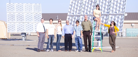 students and faculty standing in front of solar panels at UC Merced
